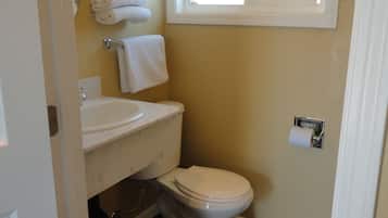 Een badkamer met toilet, wastafel en handdoekhouder.