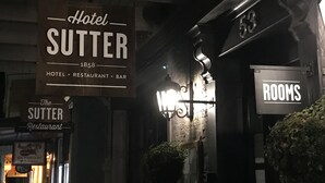 A sign for 'Hotel Sutter' with a vintage design, indicating it is a hotel, restaurant, and bar.