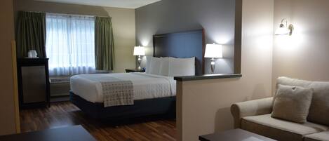A hotel room with a bed, a desk, a sofa, and a coffee table.