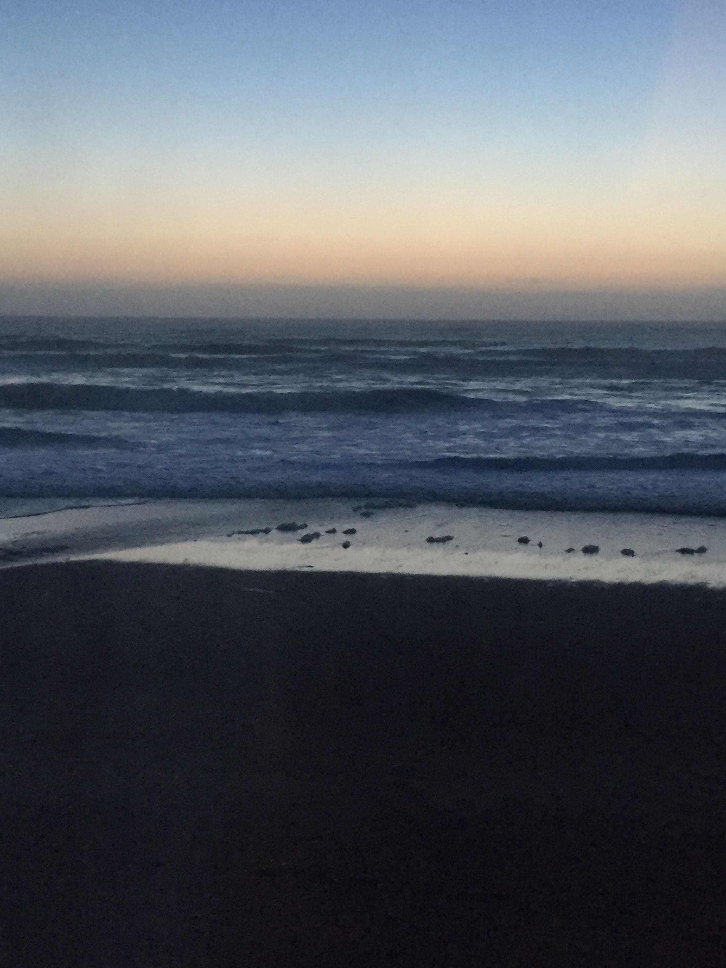 A beach with waves approaching the shore.