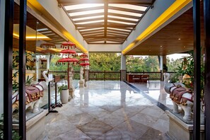 A spacious covered area with a tiled floor, red umbrellas, and statues of elephants. - The Lokha Ubud Resort, Villas & SPA (Ubud)