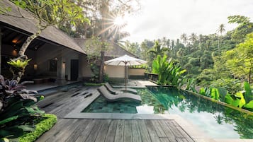 Een buitenzwembad, parasols voor strand/zwembad