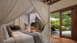 A bedroom with a canopy bed, a TV, and a view of the garden. - The Lokha Ubud Resort, Villas & SPA (Ubud)