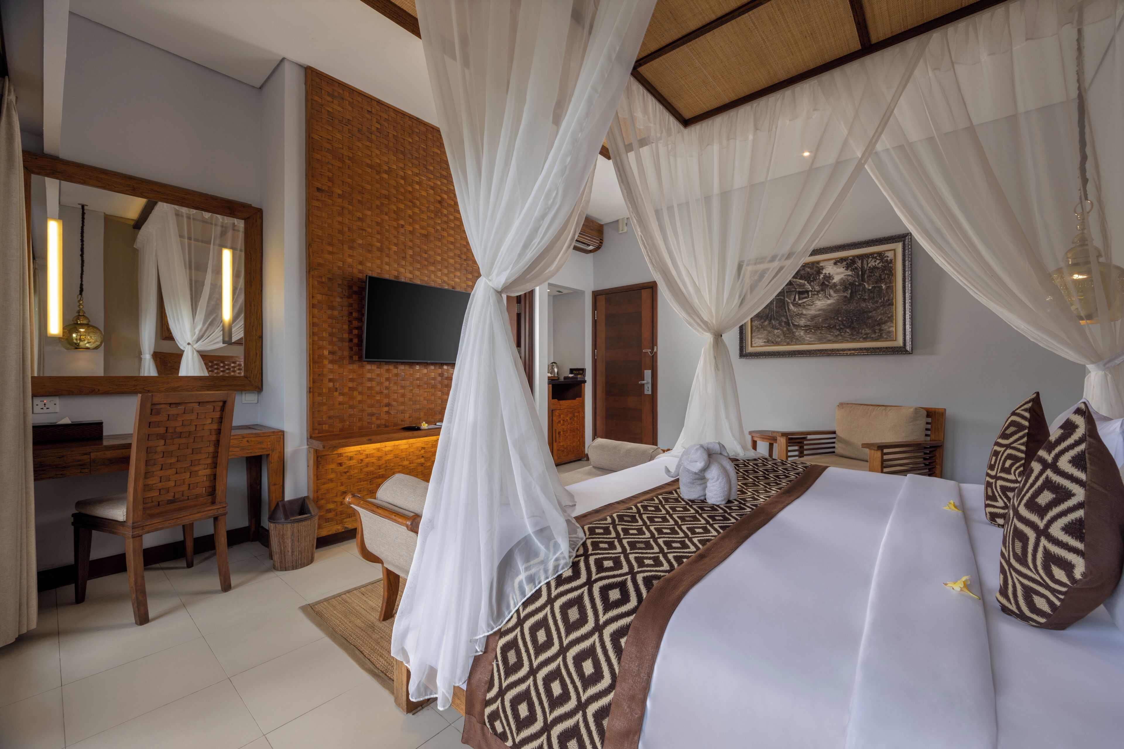 A bedroom with a bed, a desk, a chair, a TV, and a bathroom.