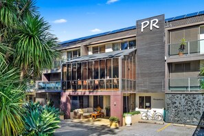 A modern building with a reception area, outdoor seating, and a bike parked outside. - Park Ridge Retreat (Gerringong)
