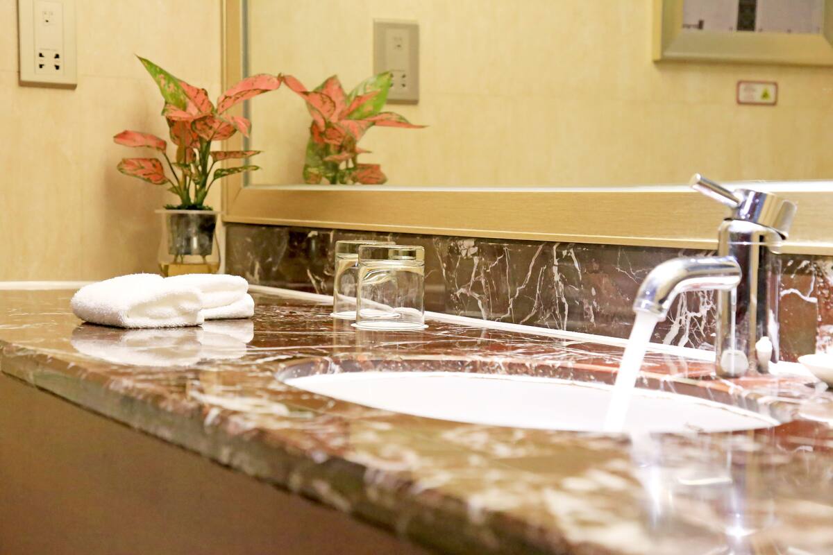 executive deluxe twin room | bathroom | shower, hair dryer, slippers, towels