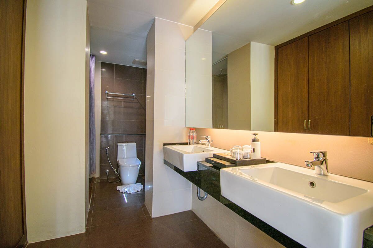 Un baño moderno con lavamanos doble, un espejo grande y cabina de ducha.