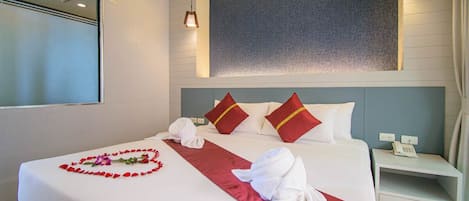 Habitación de hotel con una cama bien hecha, una mesita de noche con teléfono y un aire acondicionado de pared.
