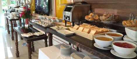 A buffet setup with various food items and a coffee machine.