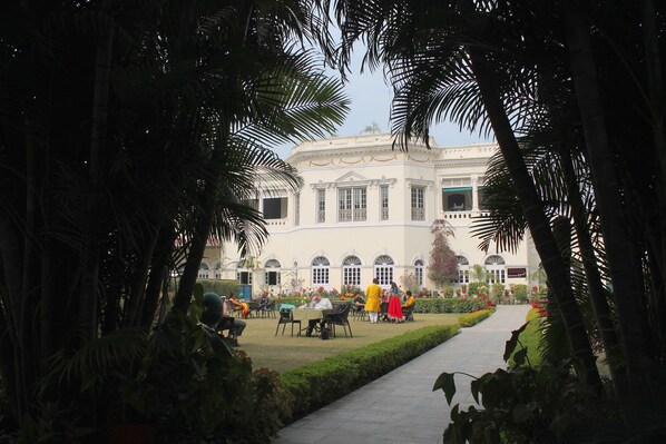 A courtyard with a building featuring arched windows and a central garden area. - Hotel Surya (Varanasi)