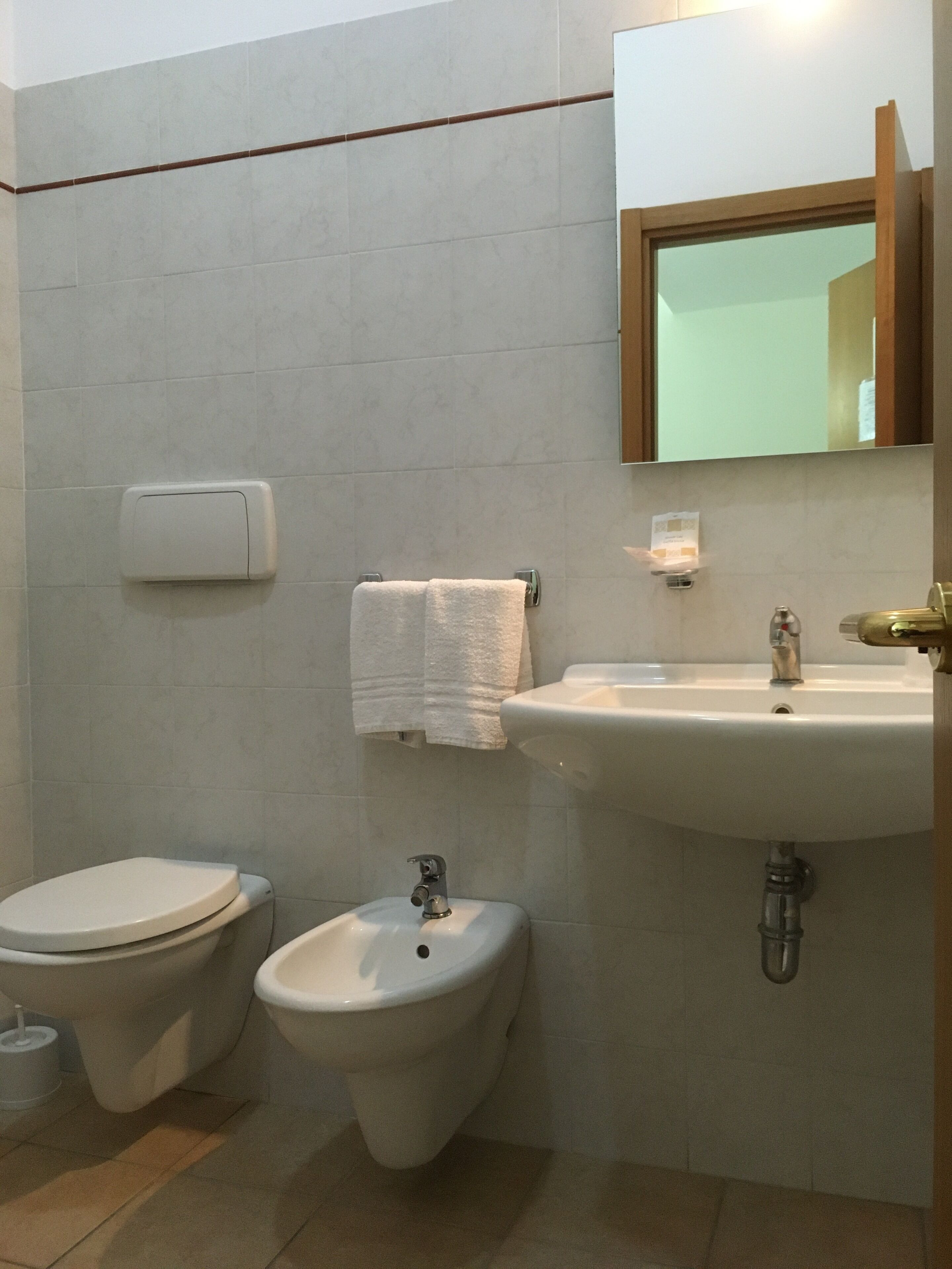 Un baño con inodoro, bidé y lavabo.
