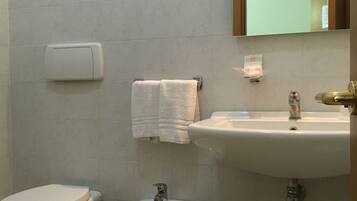 Un baño con inodoro, bidé y lavabo.