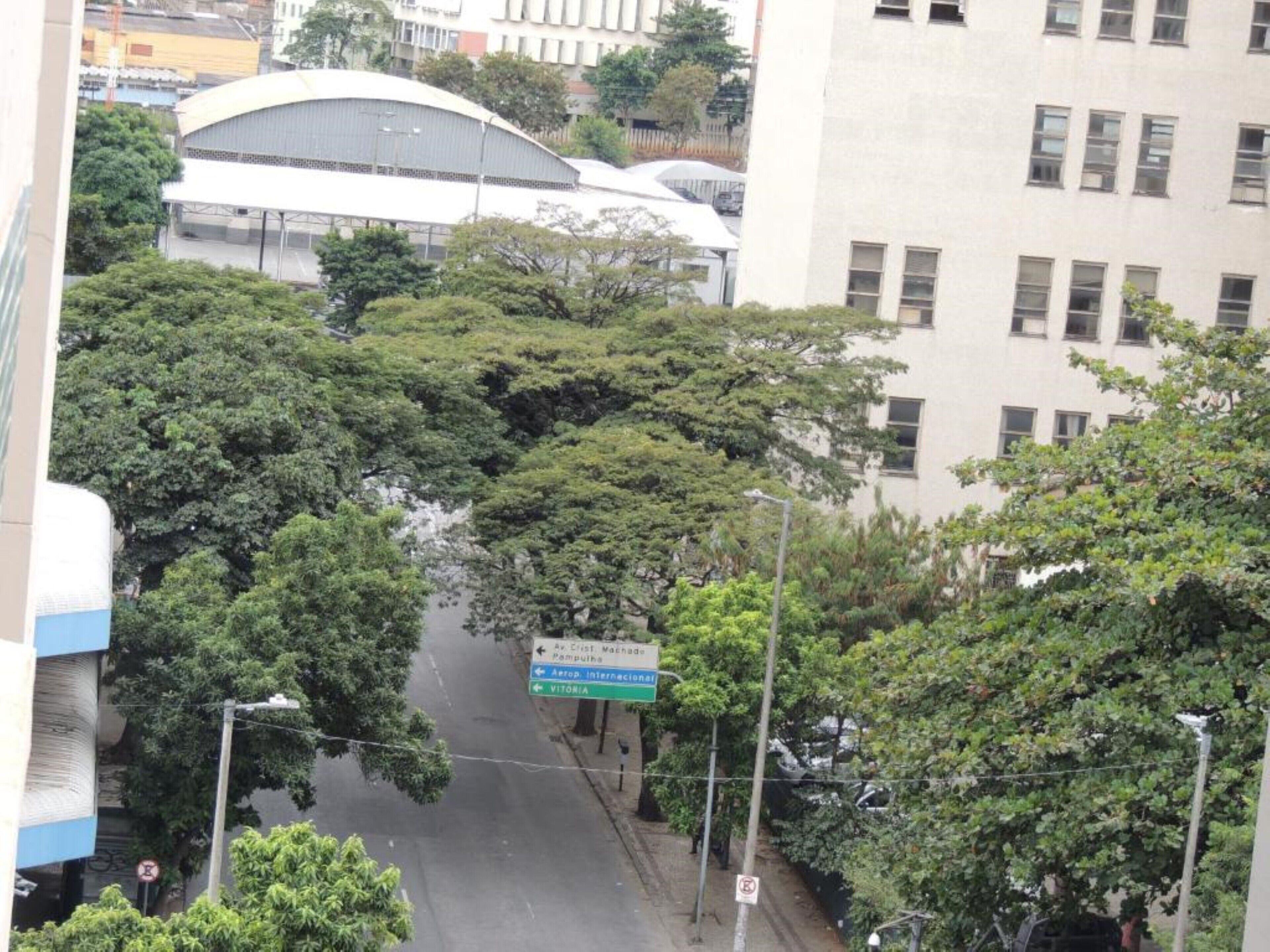 A street view with a sign indicating directions to 'Av. Cristo Machado' and 'Pampuja'.