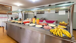 A buffet with various food items and a glass display case. - Hotel Esplanada (Belo Horizonte)