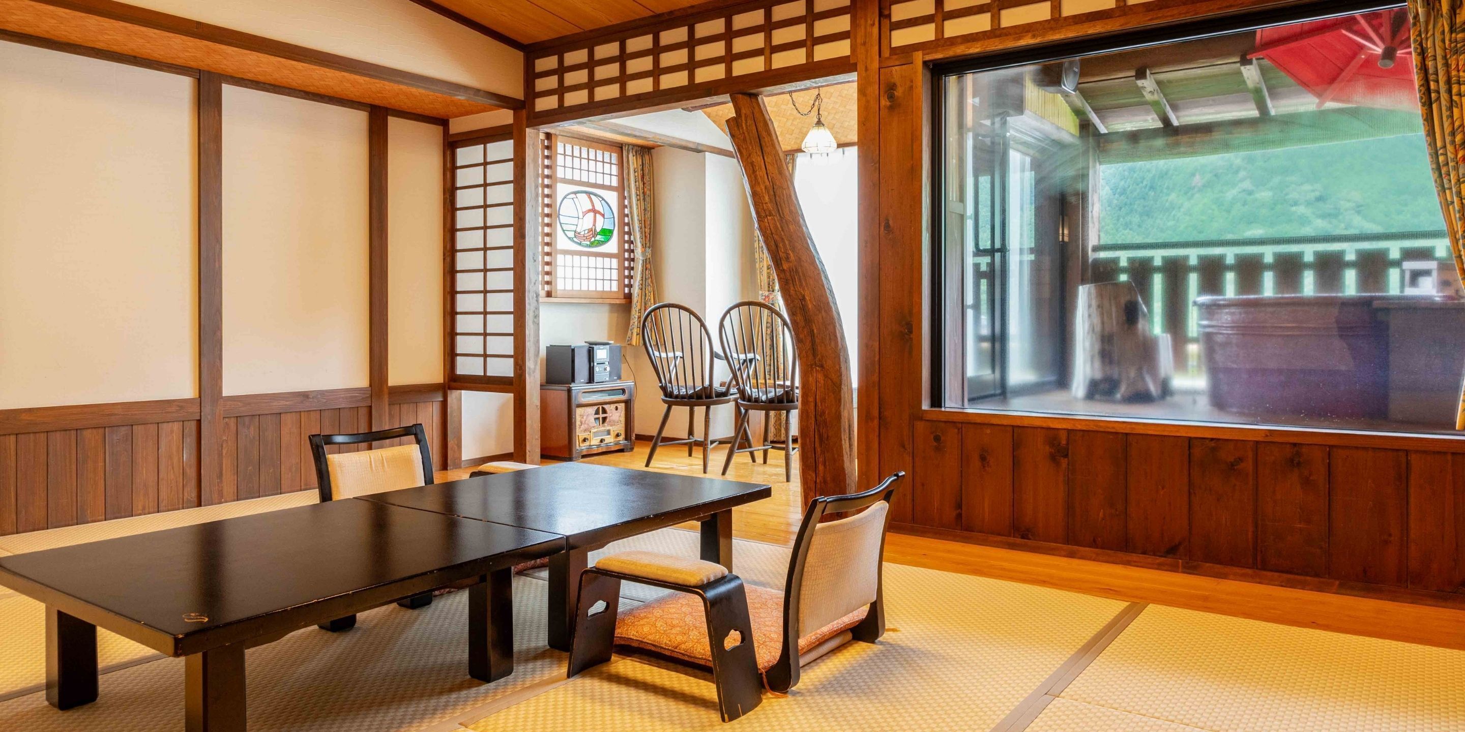 A traditional Japanese room with tatami flooring, a wooden table, and chairs.