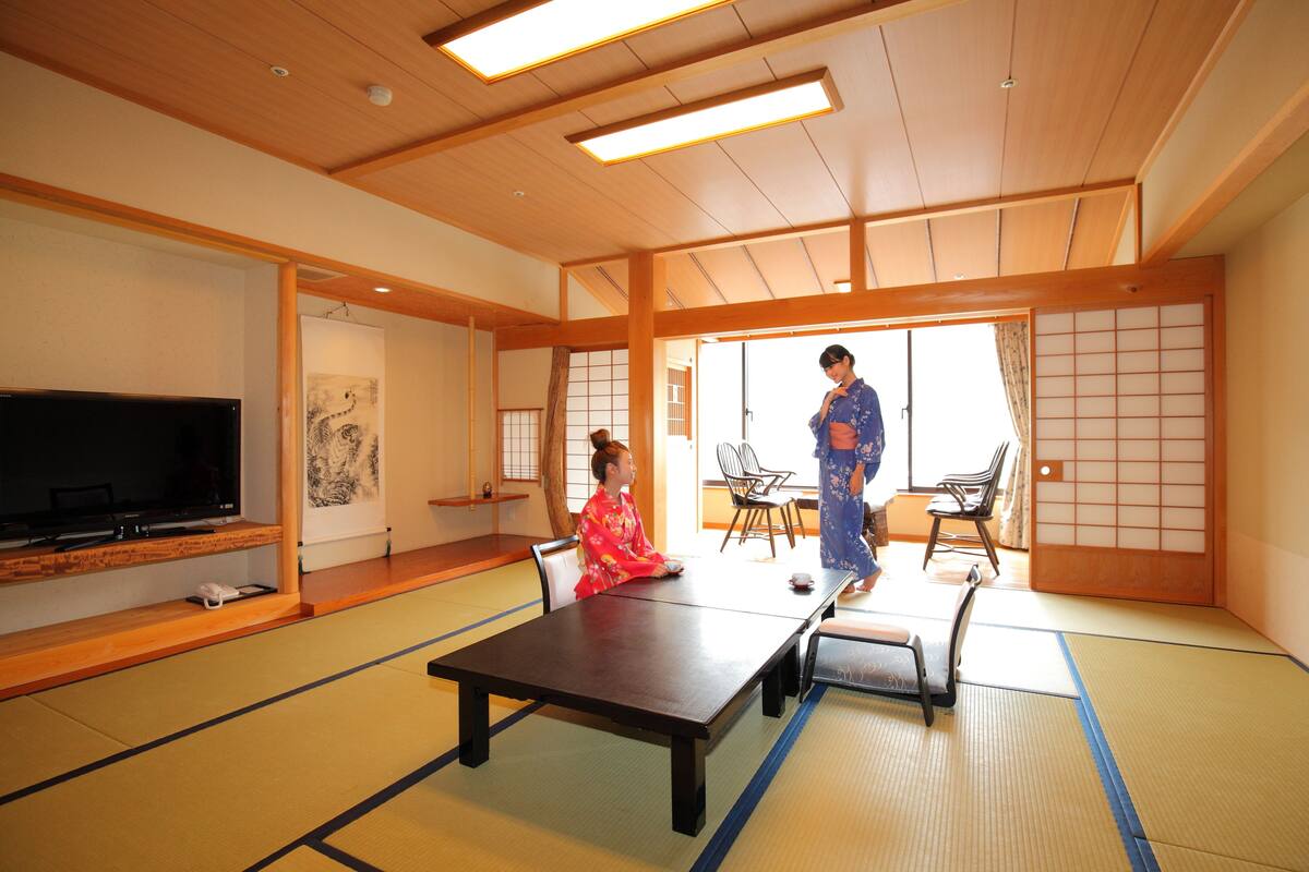 Perinteinen japanilainen huone, jossa on tatamimatto, matala pöytä ja liukuvat ovet.