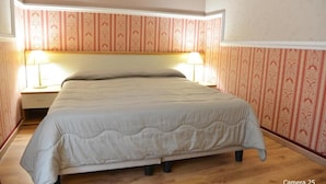 A single bed with a headboard, two bedside lamps, and a wooden floor. - Catania Centro Rooms (Catania)