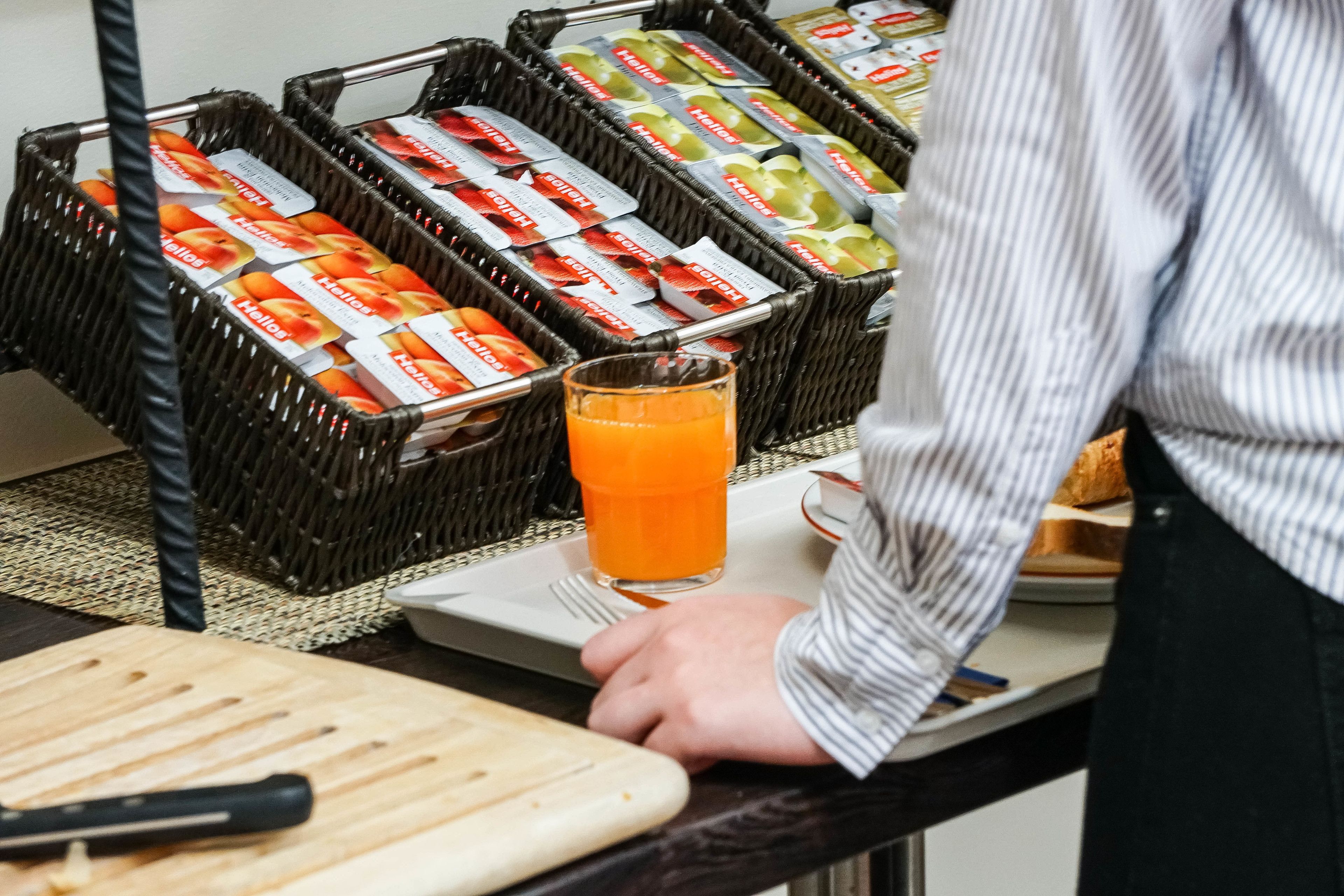 Une table préparée pour le petit-déjeuner avec du jus de fruits et une planche à découper.