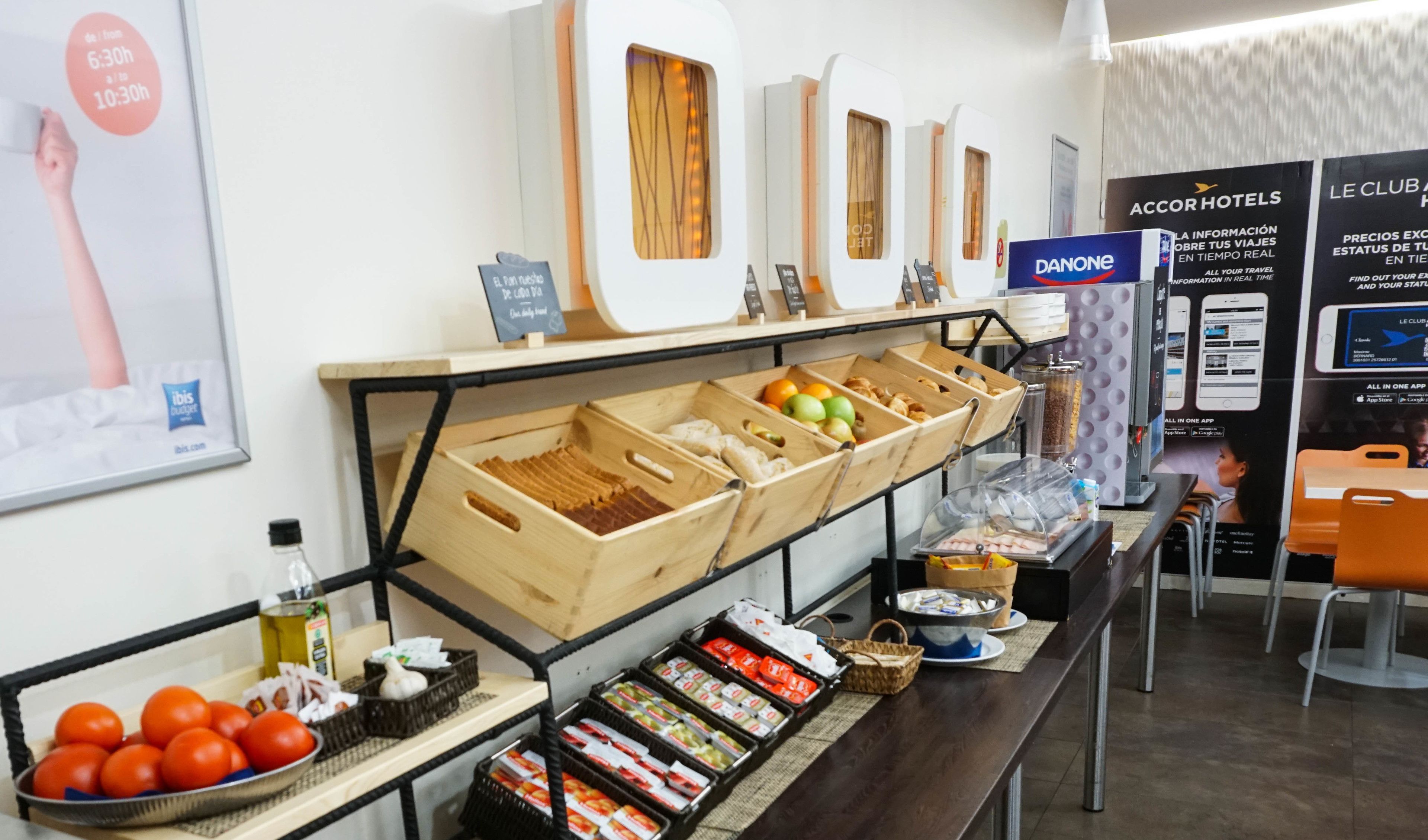 A breakfast buffet with various food items and a Danone refrigerator.