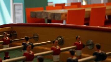 A foosball table with miniature figures in red and white uniforms.