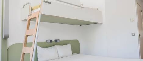 Una cama litera con escalera de madera, una mesita de noche pequeña y una lámpara fijada a la pared.