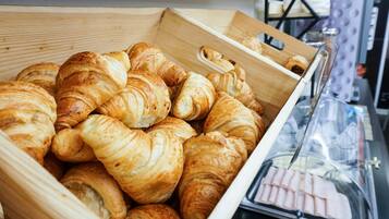 A wooden box filled with golden-brown croissants.