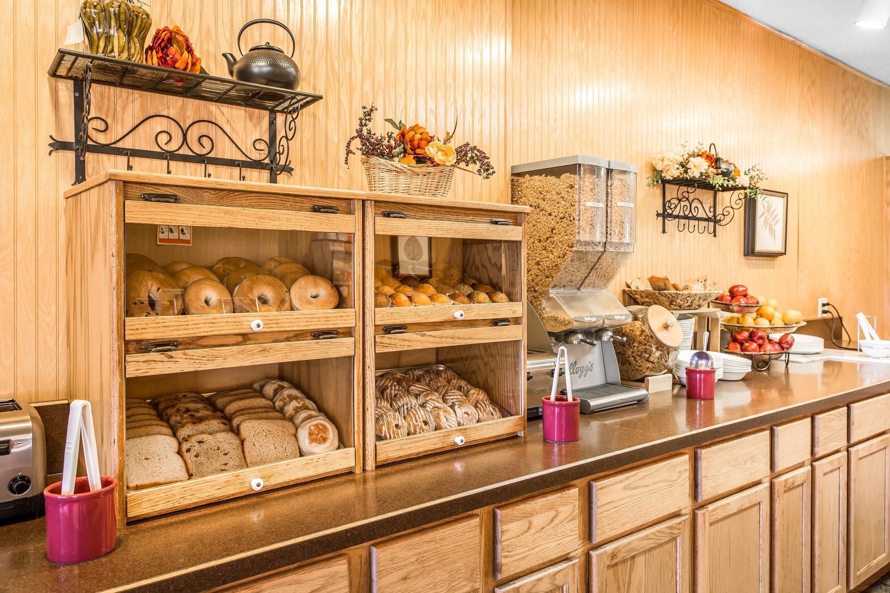 A bakery counter with various baked goods, a coffee machine, and a fruit display.