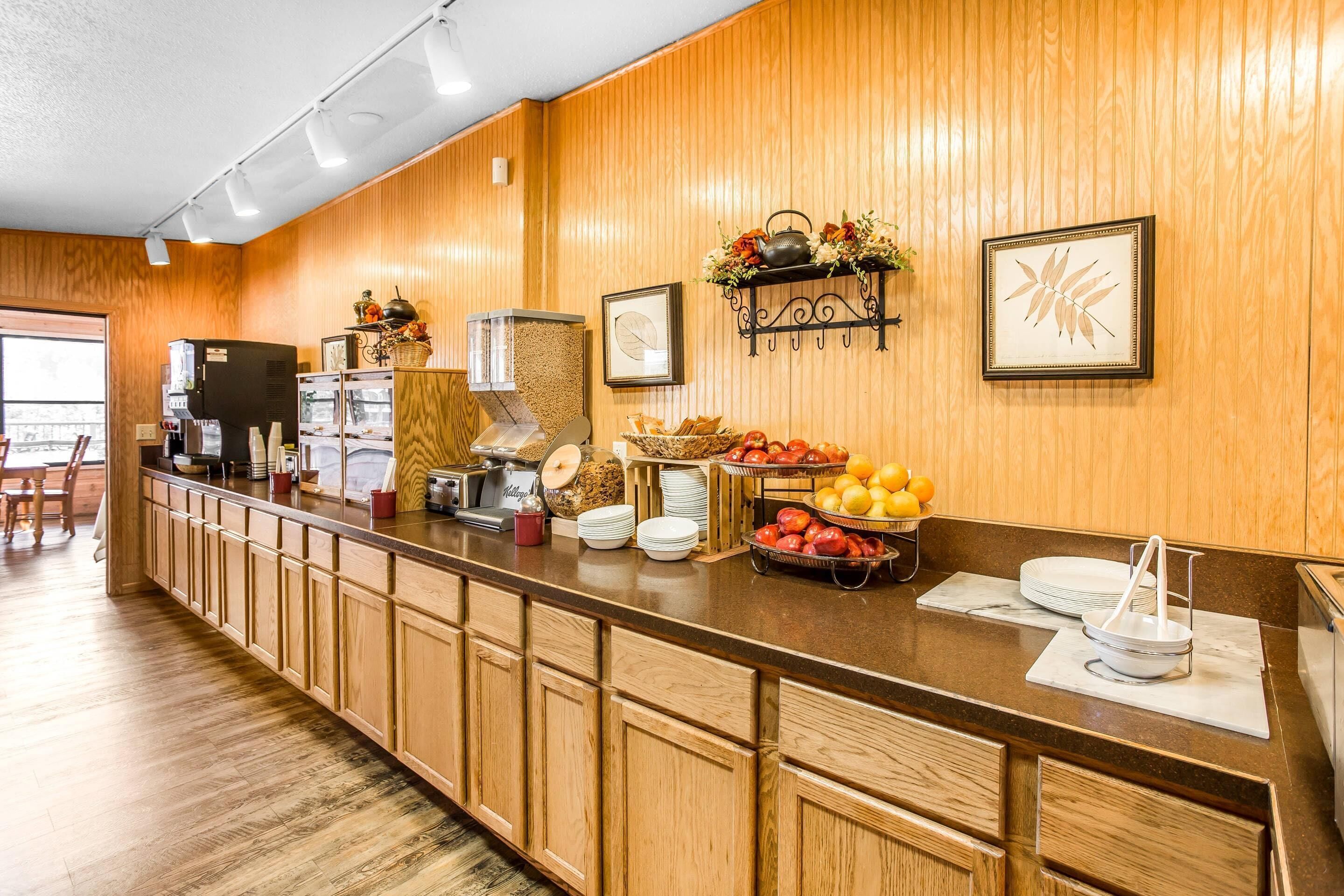 A breakfast bar with wooden cabinets, a coffee machine, and various breakfast items.