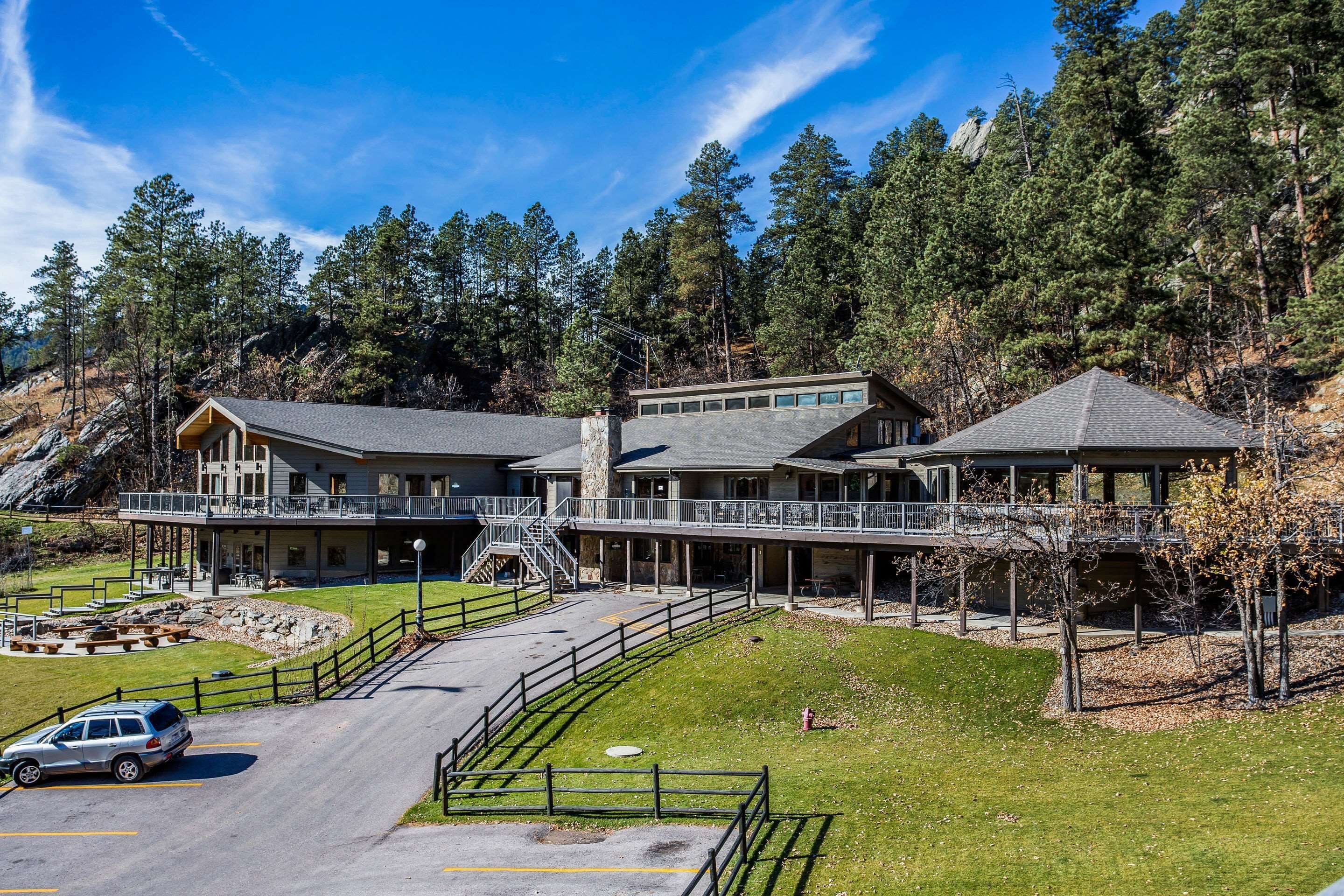 Un chalet doté d’une allée couverte, d’un espace de stationnement et surplombant un paysage montagneux.