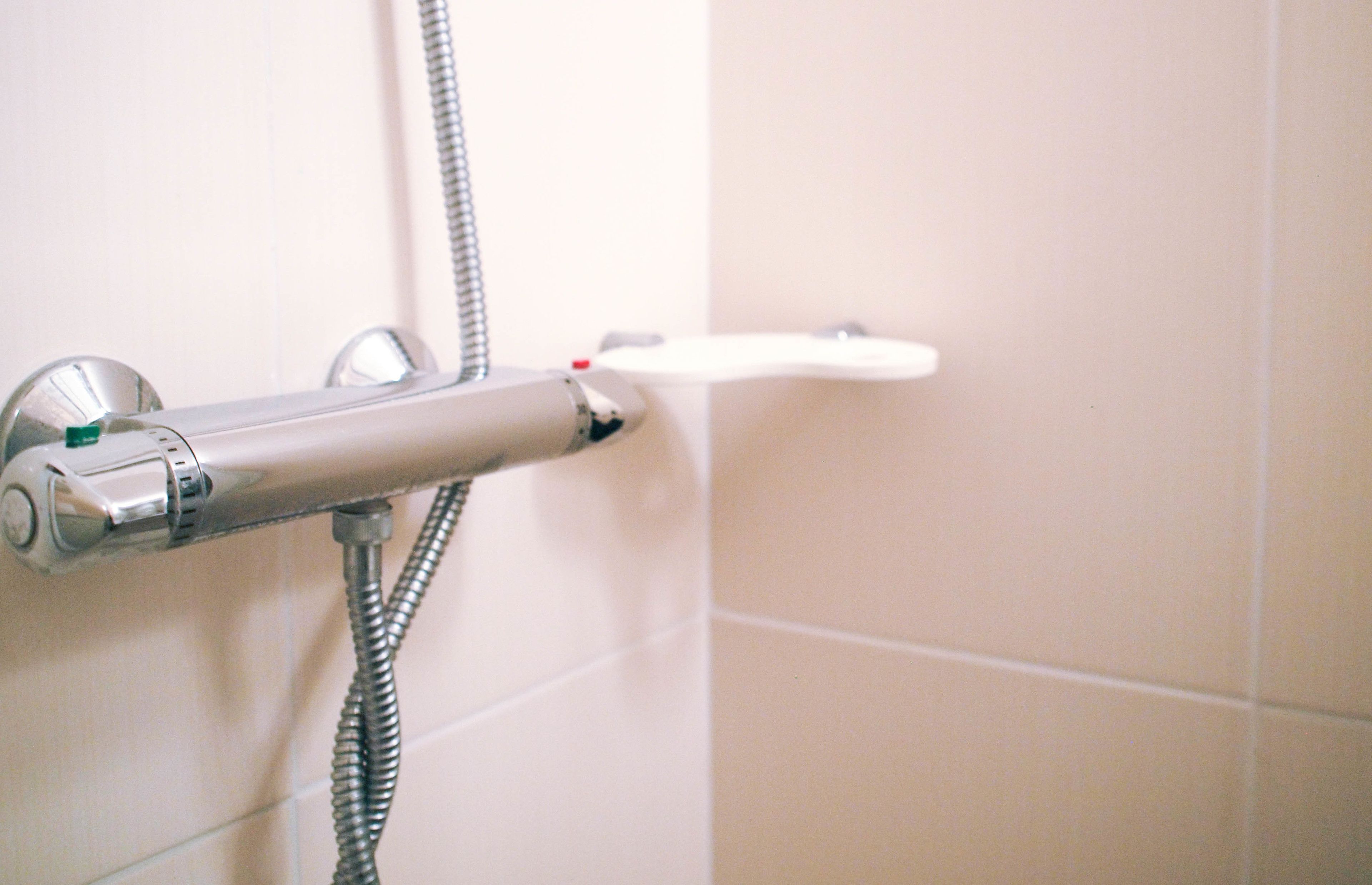 A shower with a handheld showerhead and a flexible hose.