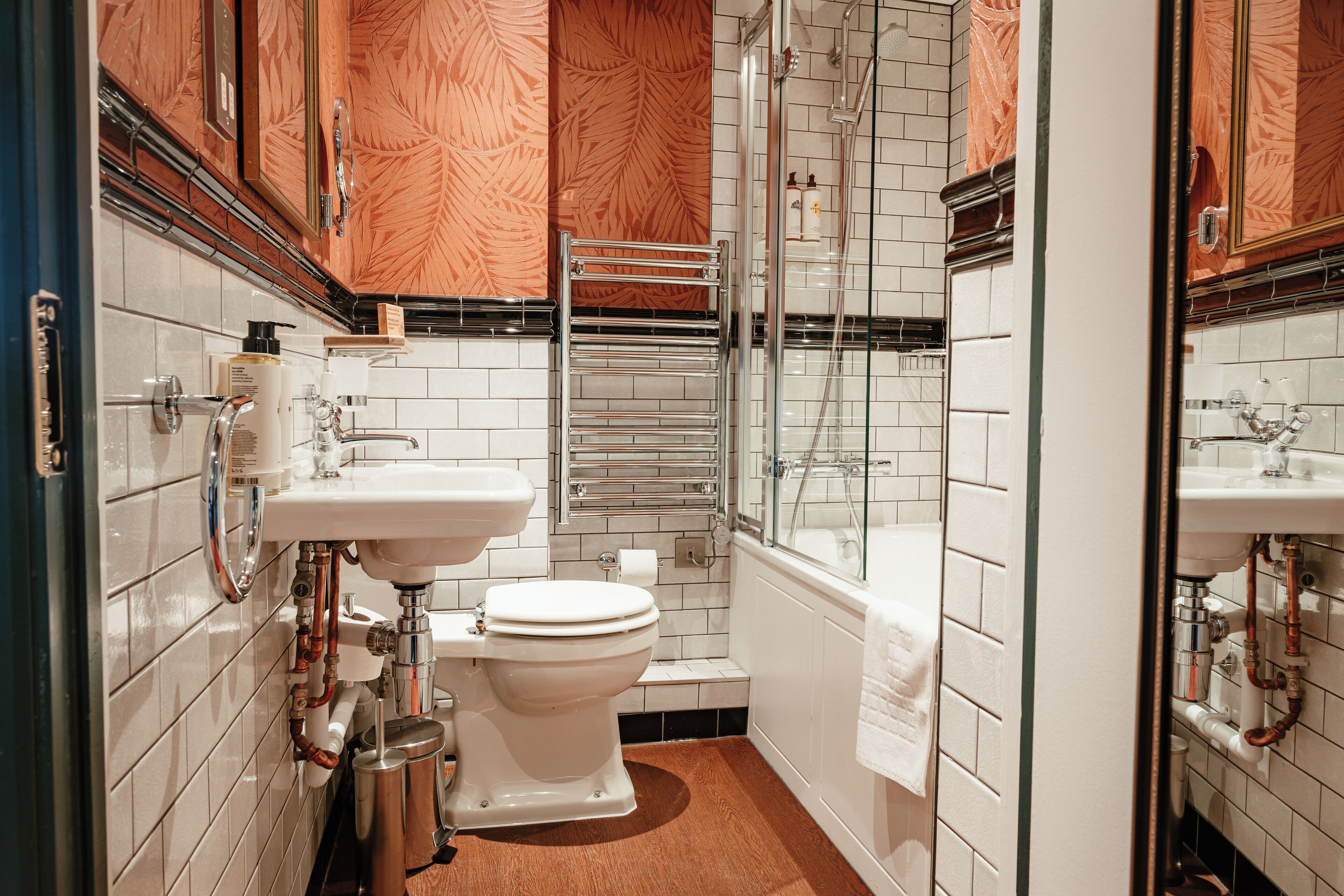 A compact bathroom with a toilet, sink, and shower.