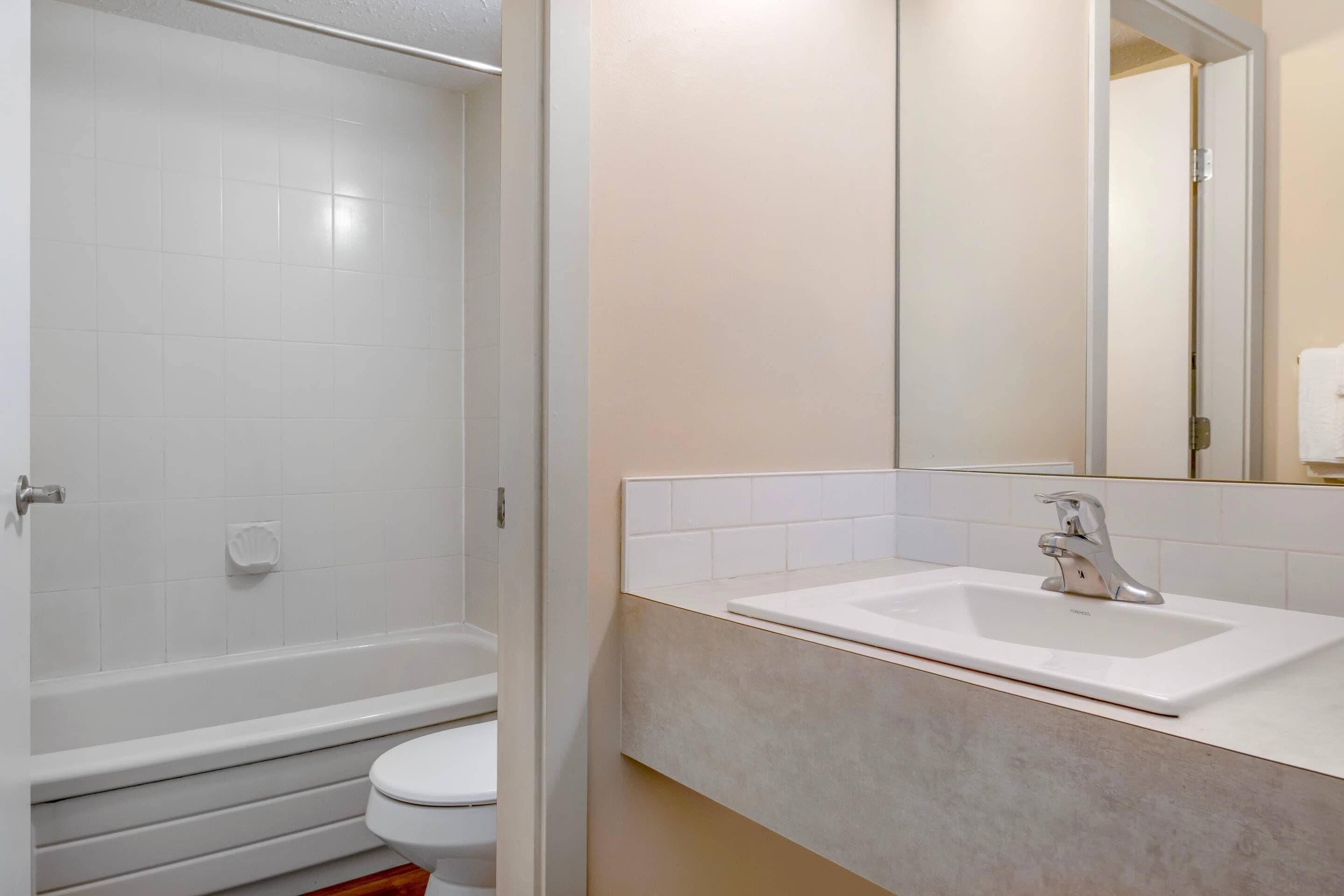 A bathroom with a bathtub, toilet, and sink.