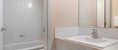 A bathroom with a bathtub, toilet, and sink.