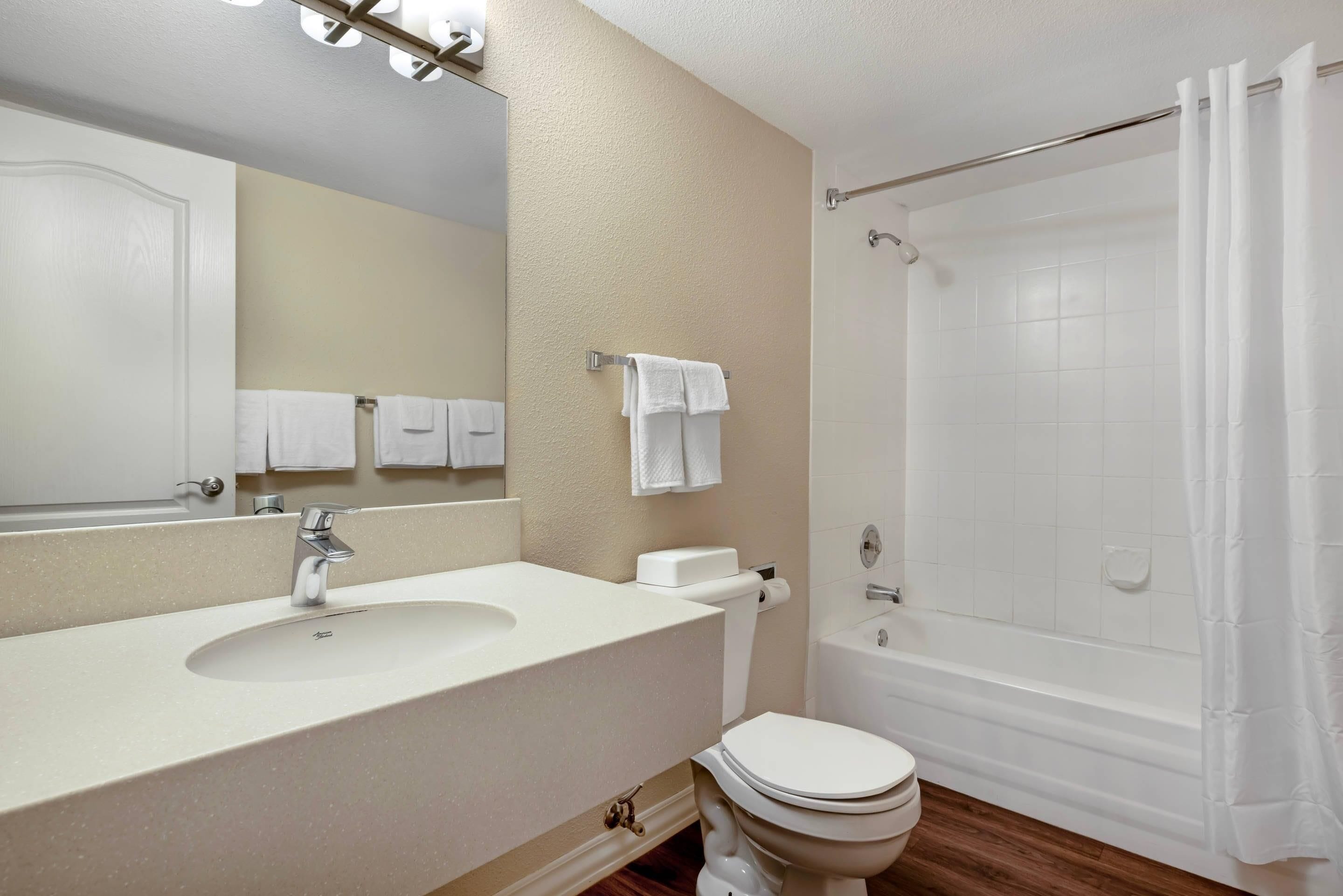 Un bagno con lavandino, WC e doccia.