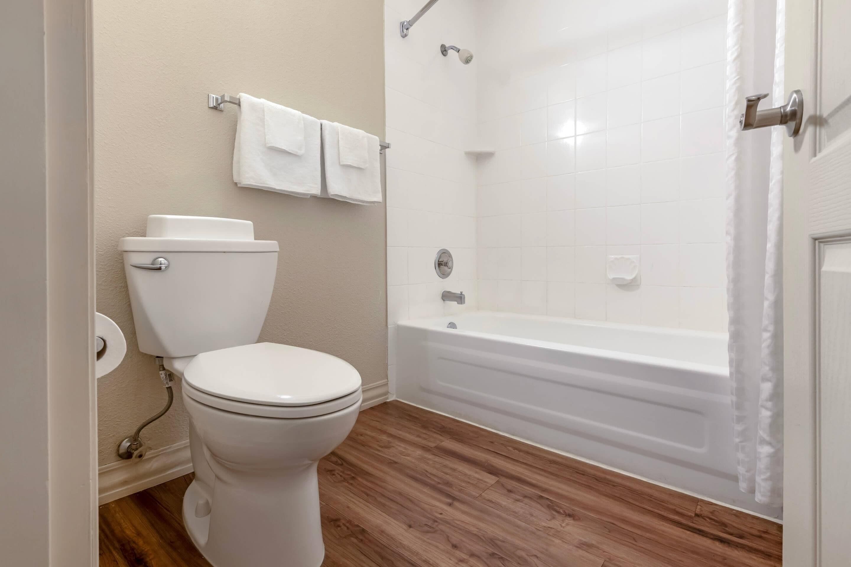Un baño con inodoro, bañera y cortina de ducha.