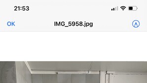 Pieni, käytännöllinen keittiö, jossa on pesuallas, pieni jääkaappi ja puinen työtaso.