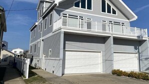A two-story house with a balcony, a garage, and a visible address number.