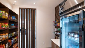 A kitchen with shelves stocked with snacks, a refrigerator with dairy products, and a wooden door. - Holiday Inn Express and Suites Little Rock Downtown by IHG (Little Rock)