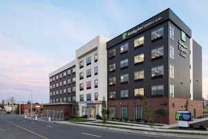Un edificio de Holiday Inn Express & Suites de diseño moderno, con varios pisos y grandes ventanales.