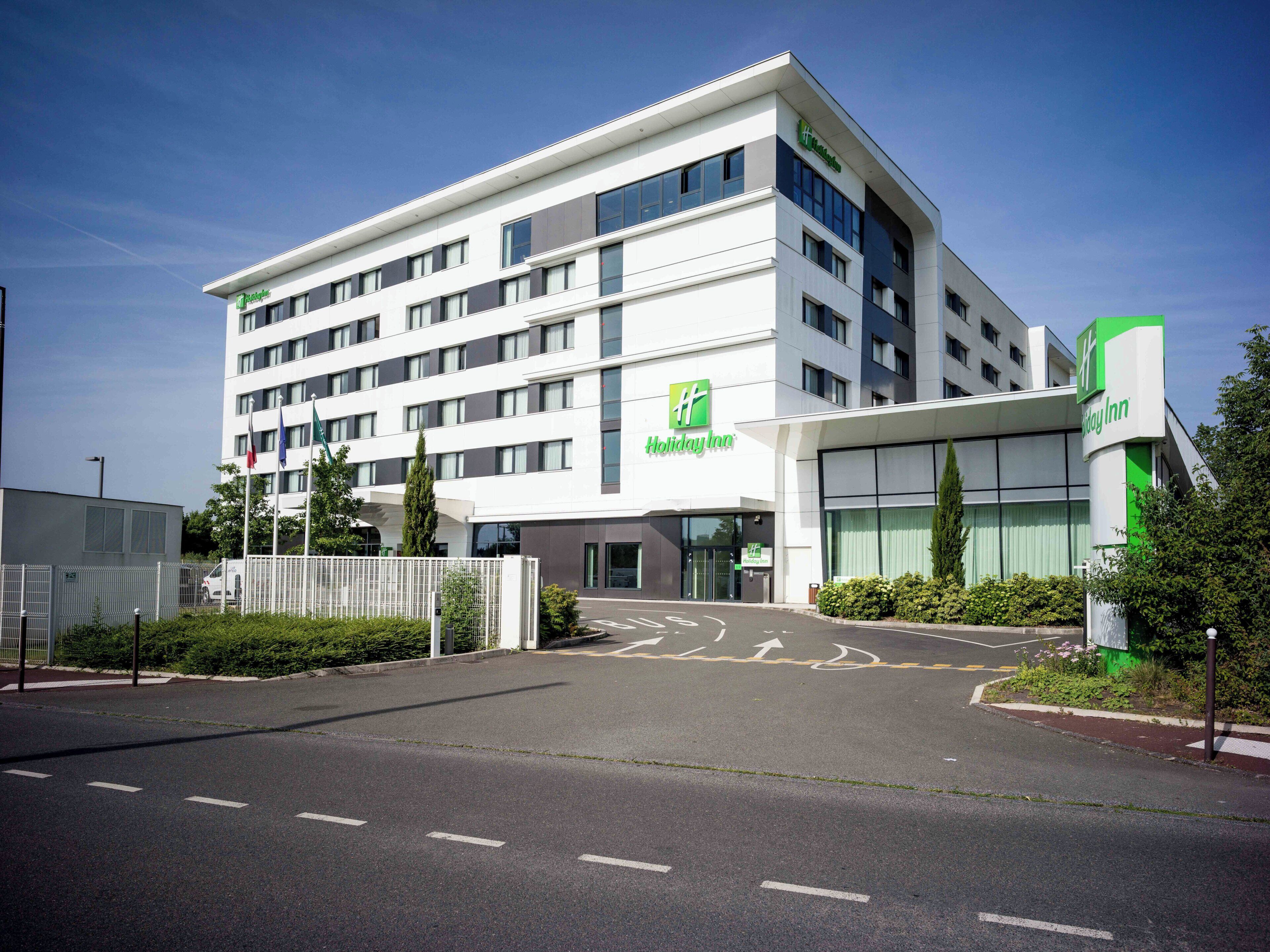 A Holiday Inn hotel with a modern design, multiple floors, and a clear entrance.