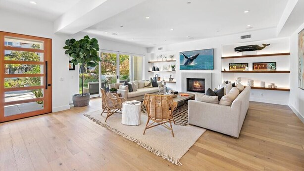 A spacious living room with a fireplace, a large window, and a view of the outdoors. - Luxury 4Bedroom home only 2 blocks from the beach! (Newport Beach)