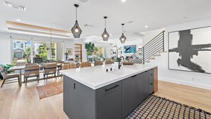 A spacious kitchen with a central island, pendant lighting, and a view to the dining area. - Luxury 4Bedroom home only 2 blocks from the beach! (Newport Beach)
