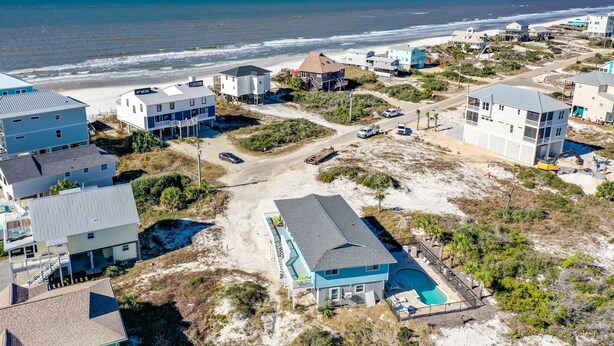 Una zona residenziale sulla costa, con case, una spiaggia e una piscina.