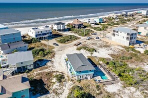 A coastal residential area with houses, a beach, and a swimming pool.