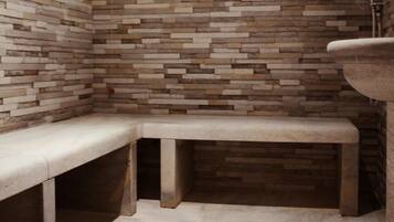 Relax in a serene space with a herringbone-patterned wall, a bench, and a stone sink.