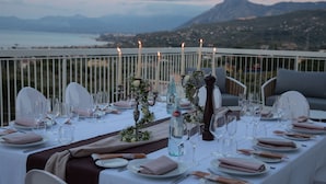 A table set for a meal with a scenic view of mountains and a body of water. - Principe Alogna Wellness & Spa (Altavilla Milicia)