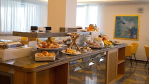 A buffet area with various food items, a coffee machine, and a painting on the wall. - Principe Alogna Wellness & Spa (Altavilla Milicia)