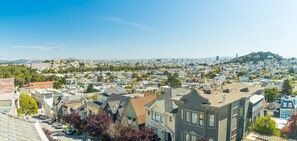 A residential area with a mix of single-family homes and apartment buildings, featuring a variety of architectural styles and a hilly backdrop. - CASABLANCA- Grand Edwardian View Home (San Francisco)