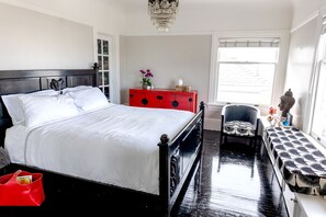 A neatly arranged bedroom with a bed, a red dresser, a chair, and a bench. - CASABLANCA- Grand Edwardian View Home (San Francisco)