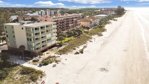 A beachfront hotel with multiple floors, balconies, and a sandy beach adjacent to the property. - Stunning Beach Views All Around... (Indian Shores)
